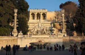 People gathering by the fountain in Piazza del Popolo, Roma, Italia.