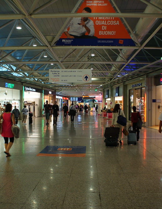 Travellers wandering past the shops in Rome Airport