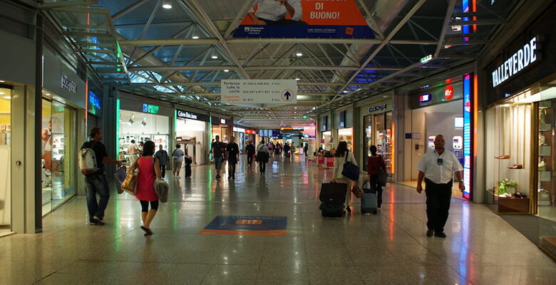 Travellers wandering past the shops in Rome Airport