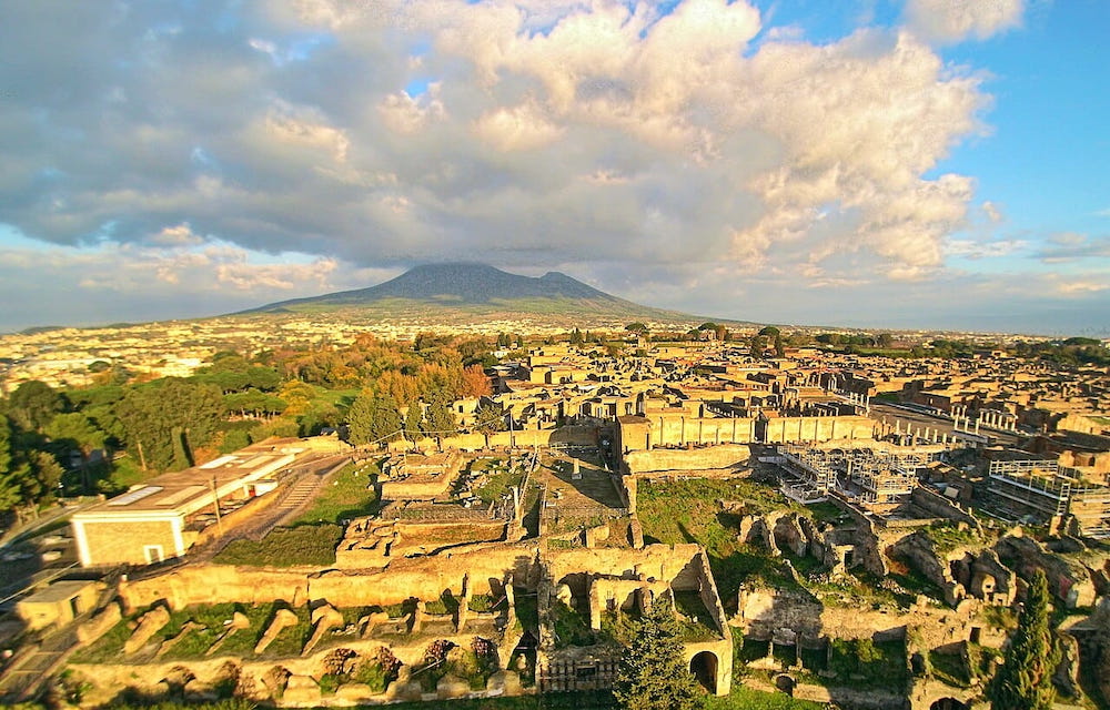 Ruins of Pompeii seen from the above with a drone, with the Vesuvius in the background.