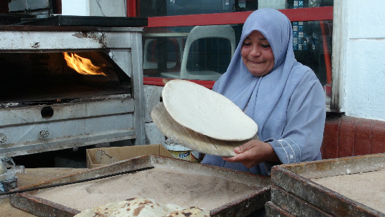 A woman making flat cread at a roadside stand in Egypt.