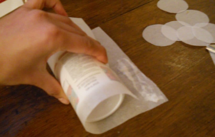 Creating Bolo de Arroz moulds by rolling a bottle in parchment paper and sealing it with flour paste.