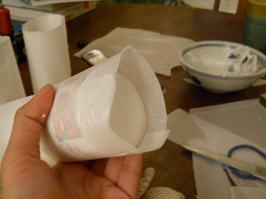 In making Bolo de Arroz moulds, let some parchment paper hang over the bottle. Cut slits into the sides of the overhang and glue down.