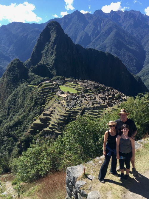 A family of three poising for a photo at Machu Picchu, Peru.