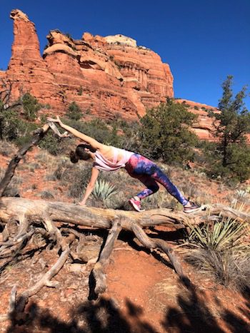 Lori Yearwood practicing a yogi pose on a fallen tree on her hike in Boynton Canyon.