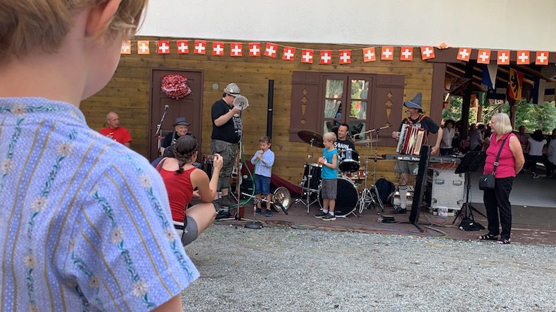 Children learning to blow the alpenhorn.