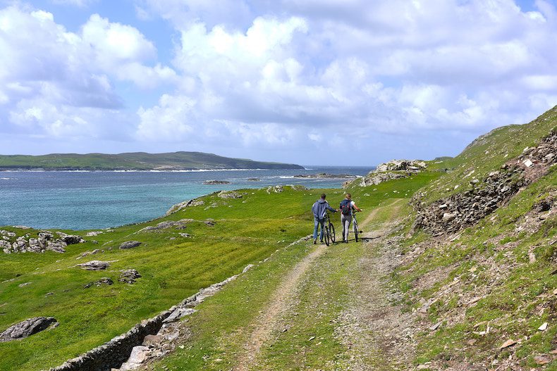 Cyclers along the Wild Atlantic Way, on the sunny shores of Inishbofin Island.