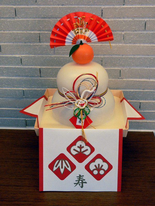 Decorative mochi with an orange on top to celebrate the New Year. Photographed by Hidetsugu Tonomura. Shared via Flickr.