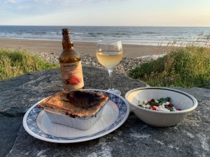 A dinner of clam rappie pie, a salad of local greens and fresh strawberries, and Corberrie Cider on Mavillette Beach.