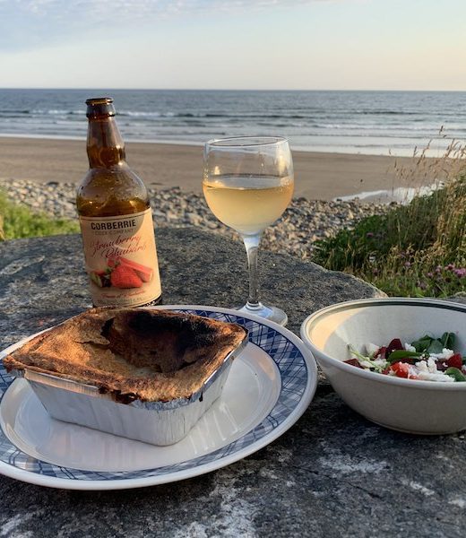 A dinner of clam rappie pie, a salad of local greens and fresh strawberries, and Corberrie Cider on Mavillette Beach.