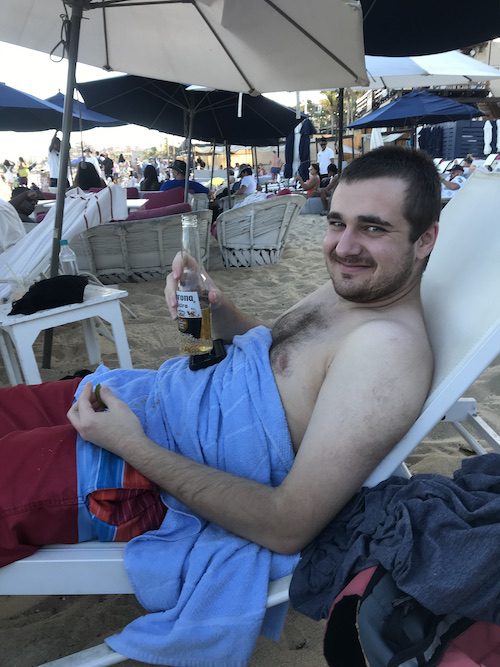 Anne's son launching in a beach chair enjoying a beer and taking in the beach party scene in Cabo San Lucas.