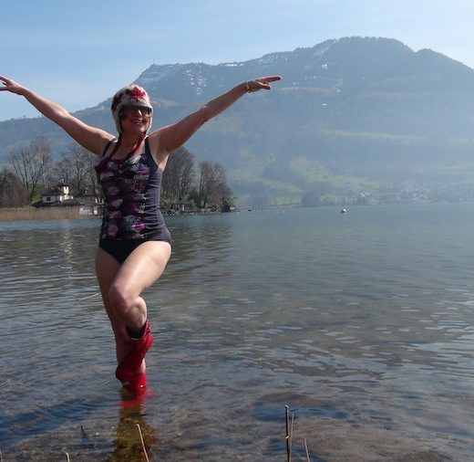 Erica doing a fun and silly swimsuit calendar girl style pose on a lake near Lucerne.