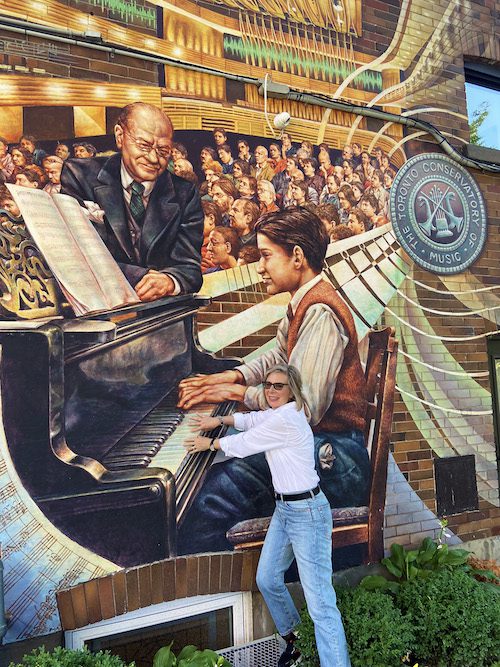 Corinne LaBossiere plays the piano with a young Glenn Gould in the Prodigy Mural.