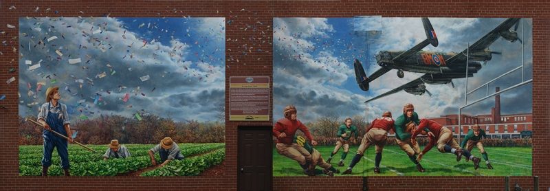 A mural depicting scenes from 1944. Harold Shipp convinced a Lancaster bomber pilot who ferried supplies from Toronto to England during the war, to fly over the school’s football field and drop hundreds of leaflets, a few of which could be traded for tickets to the school dance. Unfortunately, a rogue wind scattered the leaflets across the Chinese market gardens near Montgomery’s Inn. In the ensuing mayhem, excited football fans frantic to secure a winning ticket, stormed the field and trampled the carefully tended cabbages.