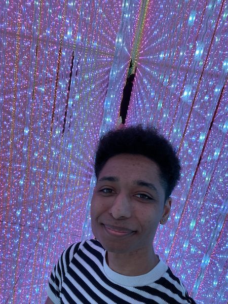 Young man surrounded by the Infinite Crystal Universe illusion at teamLab Planets