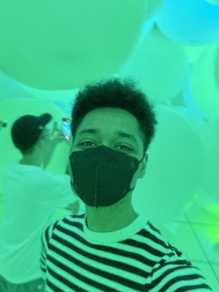 Young man surrounded by spheres of light at teamLab Planets.