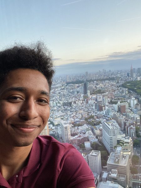 A young man with the view of Tokyo from Shibuya Sky.