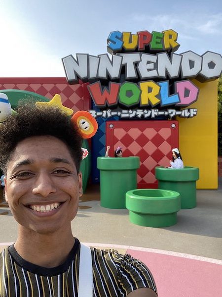 A smiling young man excited to be visiting Super Nintendo World.
