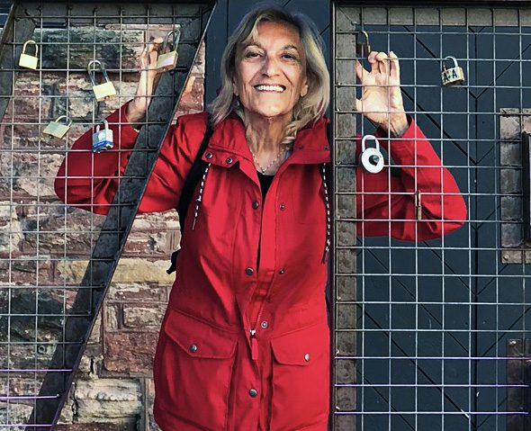Woman in a red raincoat, smiling.