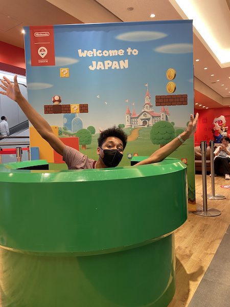 Young man poising enthusiastically as a part of Ninetendo's Welcome to Japan exhibit.