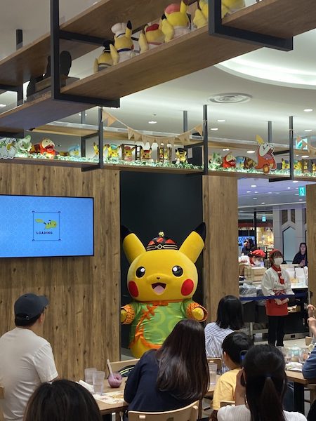 Pikachu, dressed in traditional Japanese attire, greeting guests at Pokemon Cafe.