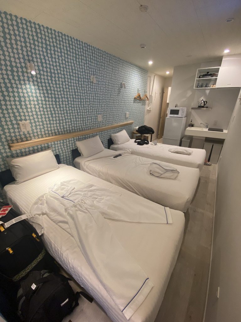 3 beds in a row in a narrow, but brightly lit and clean U-Hotel Takadanobaba room.