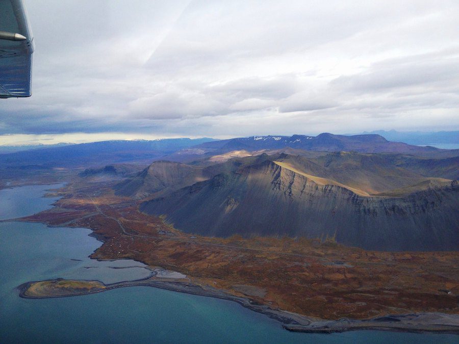 Looking down on an expanse of uninhabited mountains and coastline of Iceland, from an airplane.