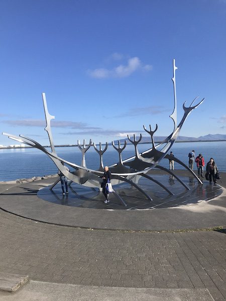 Woman poising for a photo in front of the hull of the Sun Voyager  in Reykjavik, Iceland.