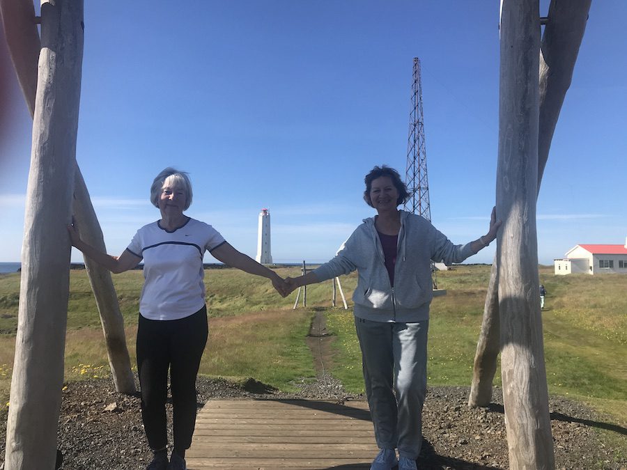 Vera and Anne, wind swept and rosy cheeked, hand in hand with the  Malarrif lighthouse in the background.