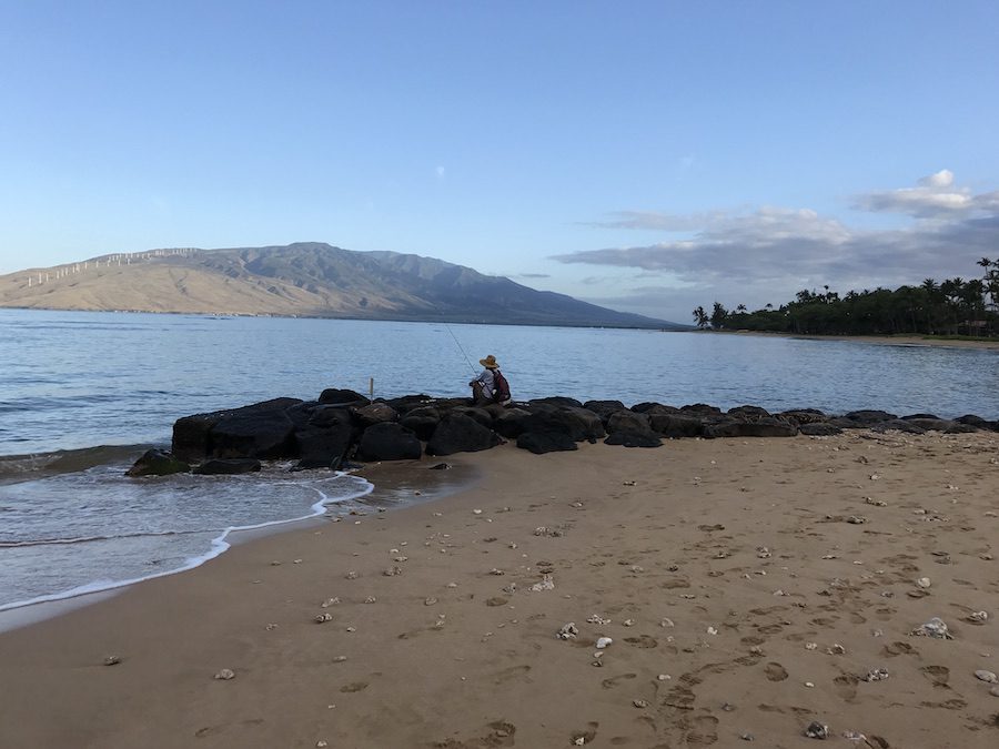 An early morning fisherman casting hi s line from the beach in Kihei.
