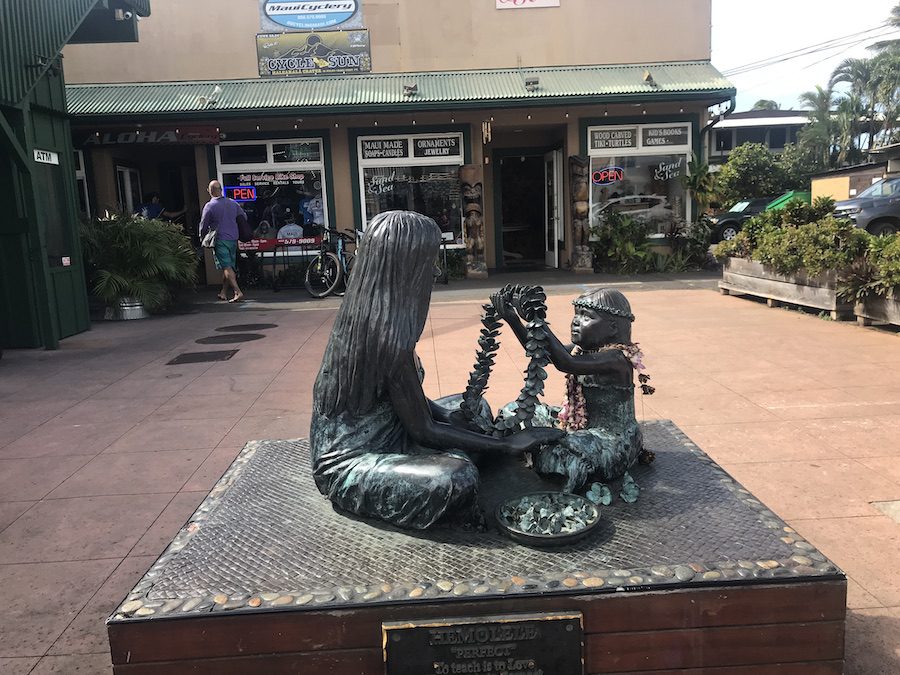 A statue in Pa’ia of a little girl in Hula attire giving a woman a lei.