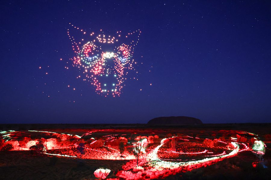 Hundreds of drones create the image of the evil Kurpany while Uluru stands silent in the distance .