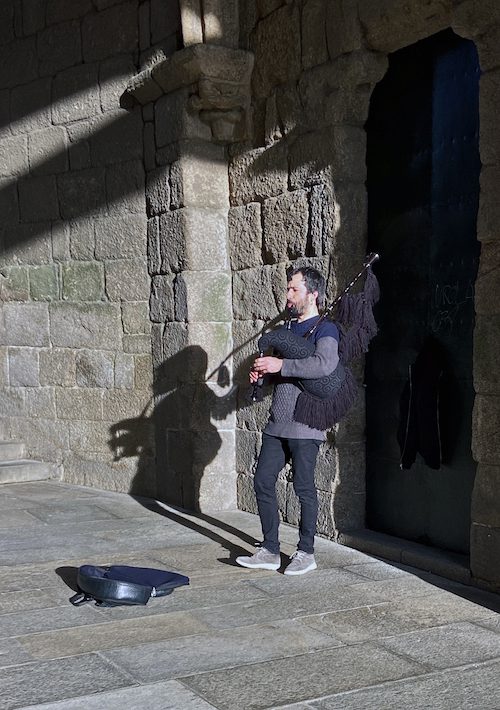 A Galician piper welcomes pilgrims at the entrance to Praza do Obradoiro, the largest square in Santiago de Compostela.