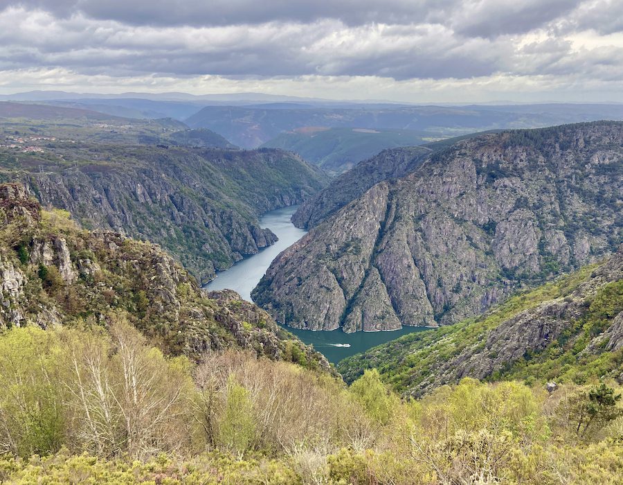 A tour boat looks tiny on the River Sil which carves its way through the landscape of the Ribeira Sacra.