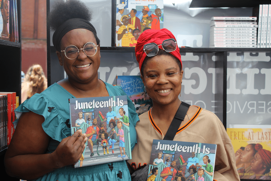 Pamela Pascal with the author of Juneteenth Is, Natasha Tripplett, holding up the children's book.