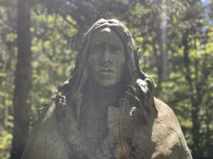 Gerry Squire's Spirit of Shanawdithit statue in the forest on the trail to the Beothuk Village at the Beothuk Interpretation Centre in Boyd's Cove, Newfoundland.