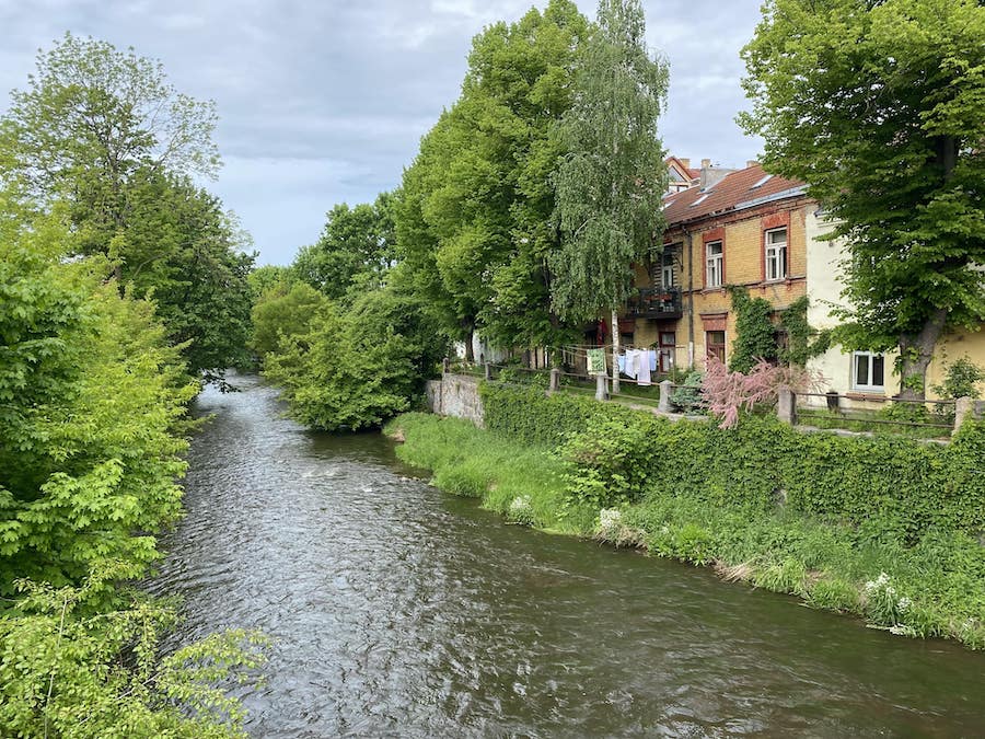 Houses along a stream in the Baltic countryside.
