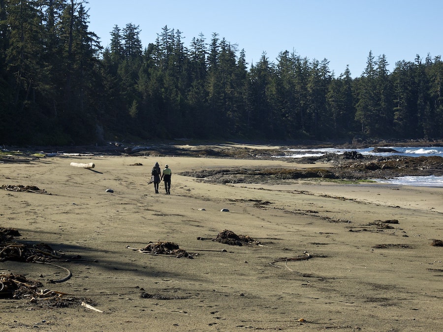 A couple holding hands as they walk along Tapaltos Beach.