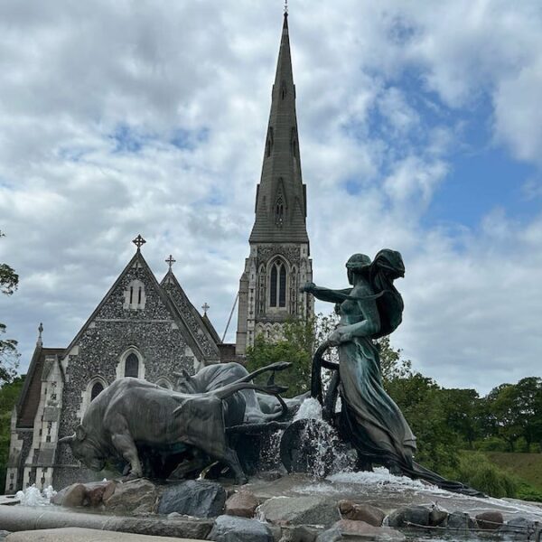Goddess and oxen statue in the fountain with St. Alban's Church in behind.