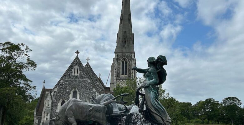 Goddess and oxen statue in the fountain with St. Alban's Church in behind.