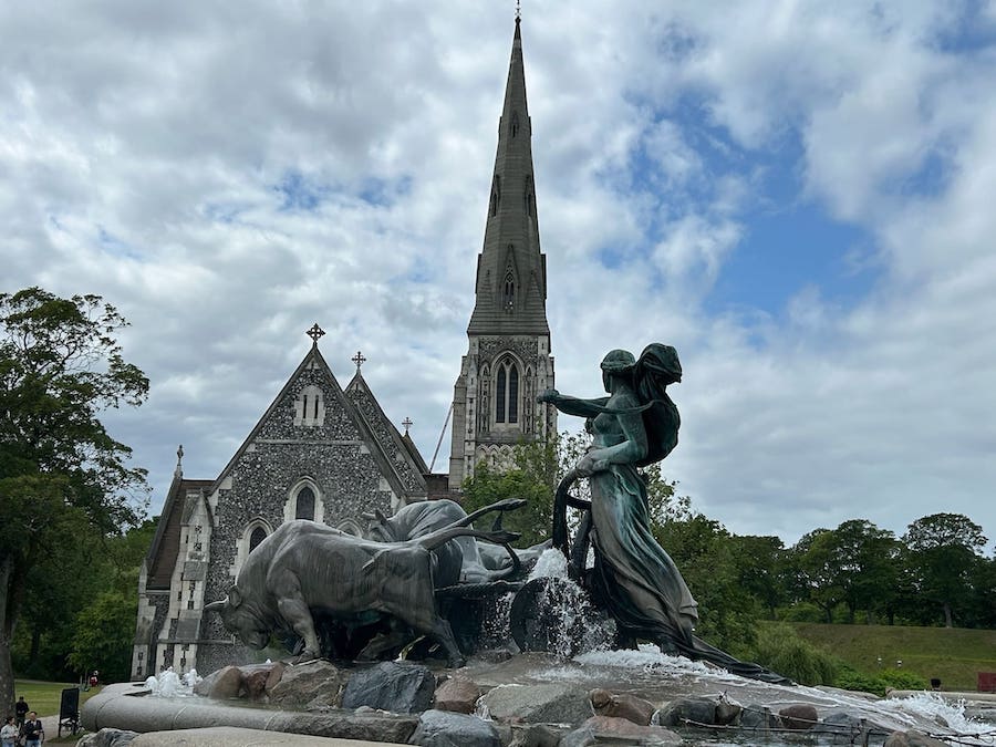 Goddess and oxen statue in the fountain with St. Alban's Church in behind.