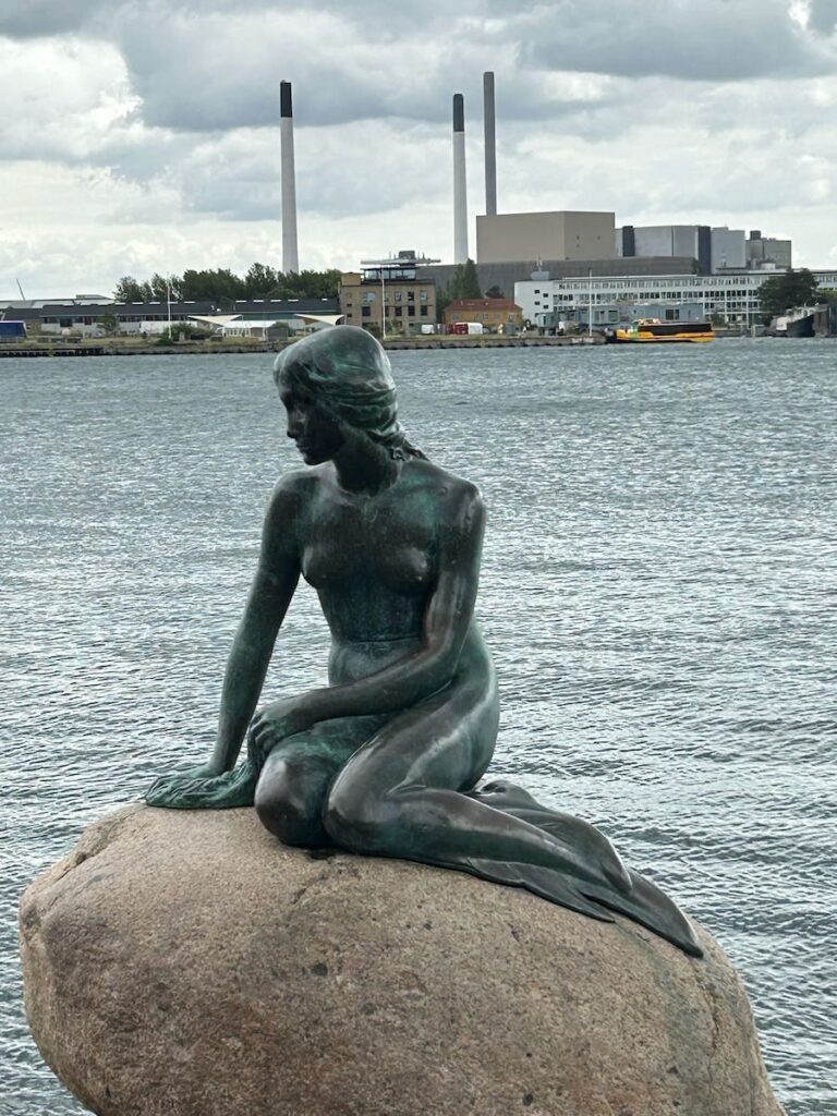 Little Mermaid sitting on the rock over the harbour  in Copenhagen, Denmark