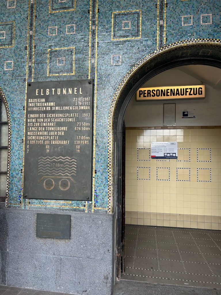 Arched entrance to the Alter Elbtunnel with blue tiles on the outer wall.