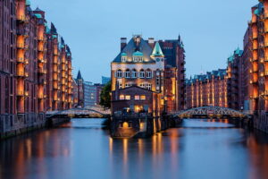 Evening lights reflecting off the water at Wasserschloss in the Speicherstadt in Hamburg, Germany.