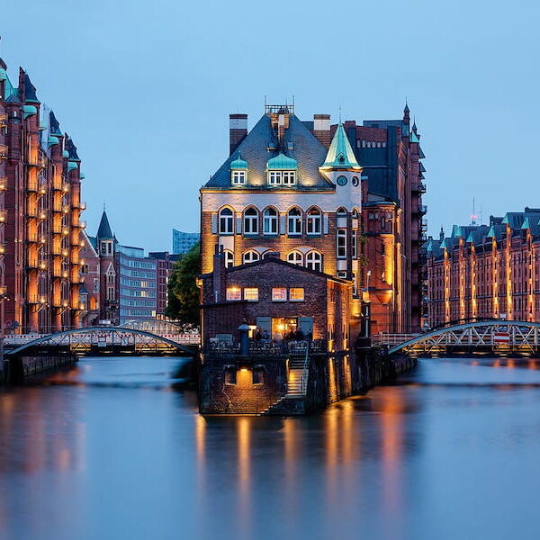 Evening lights reflecting off the water at Wasserschloss in the Speicherstadt in Hamburg, Germany.