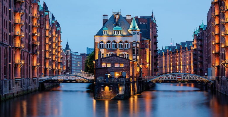 Evening lights reflecting off the water at Wasserschloss in the Speicherstadt in Hamburg, Germany.