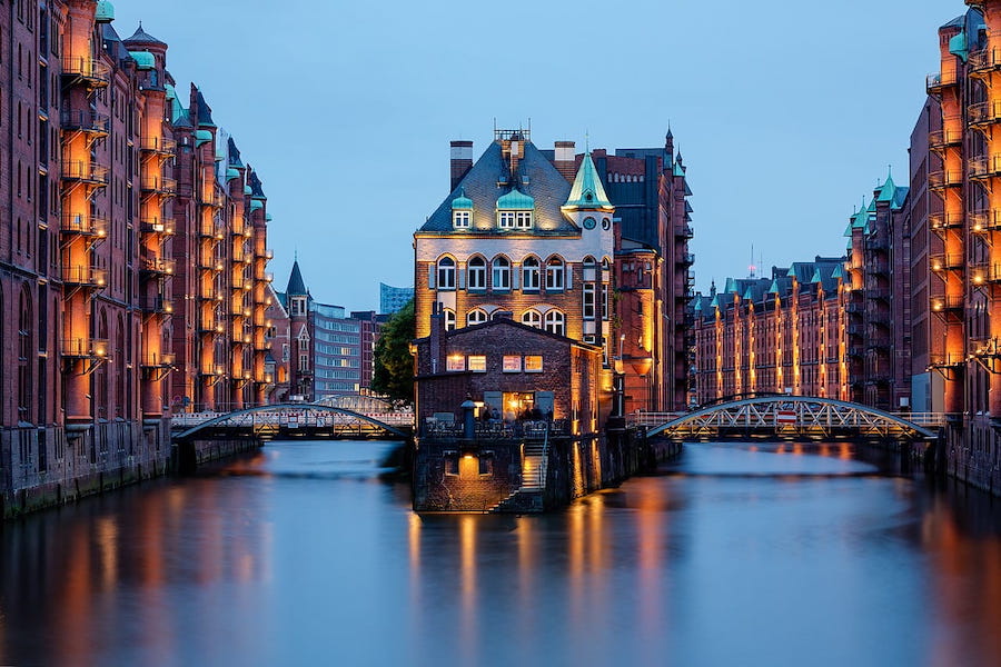 Evening lights reflecting off the water at Wasserschloss in the Speicherstadt in Hamburg, Germany.