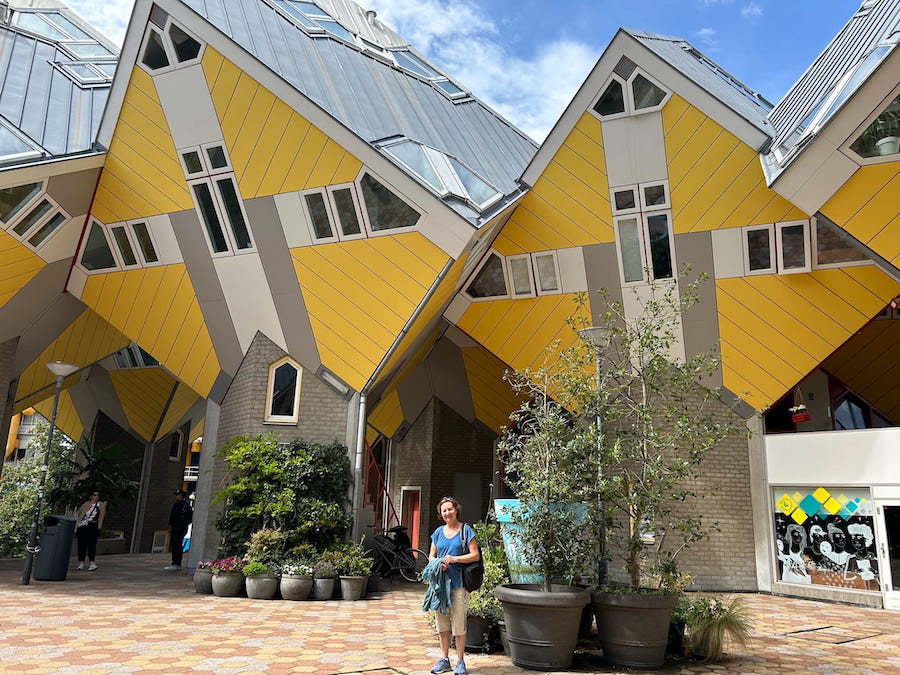 Writer Anne Webster poises for a picture in the courtyard of Kijk-Kubus, Rotterdam's leaning, yellow Cube Houses.