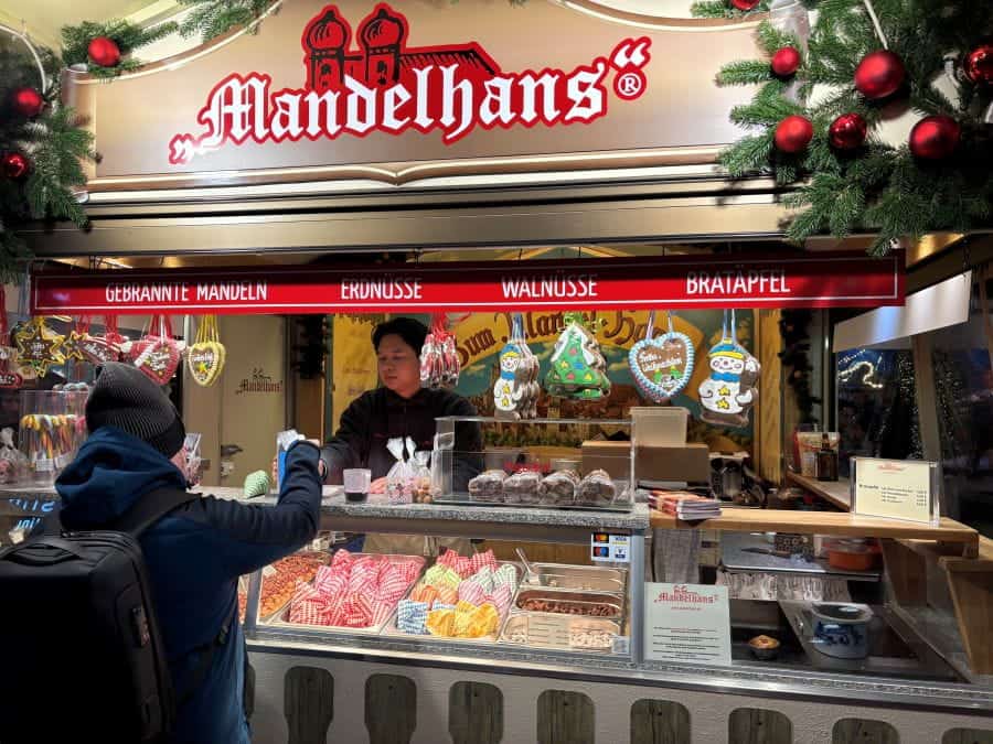 Buying hot roasted nuts from a from Mandelhans vender at a German Christmas Market.