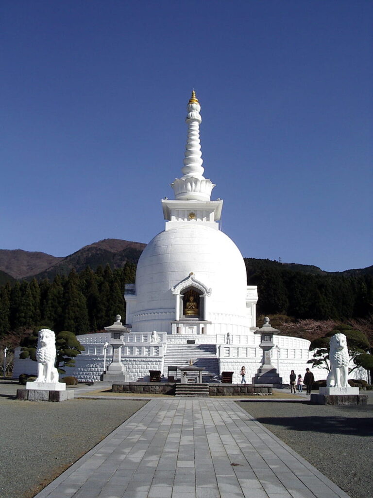 White domed Peace Stupa in Gotemba, flanked by two lions.